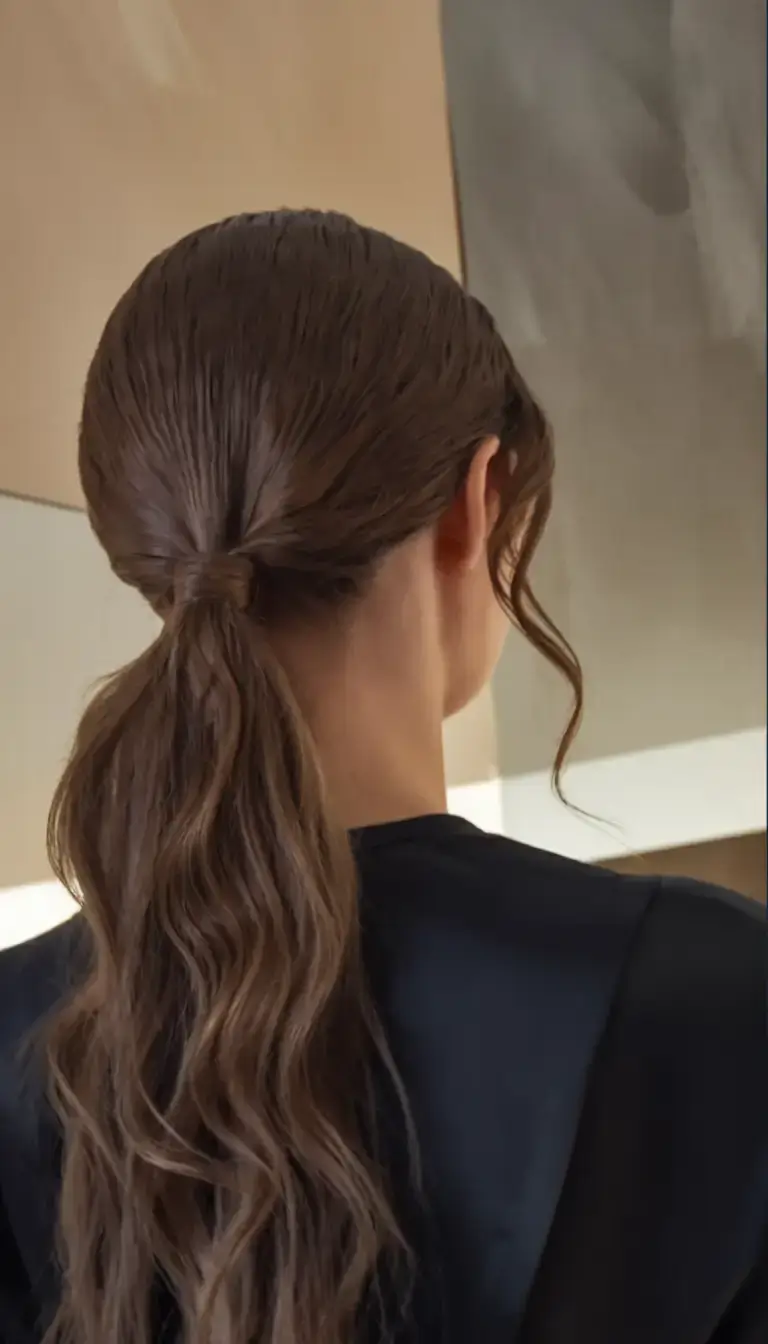 fresh hairstyles for june 2025 Wet-Look Waves in a Low Loop
