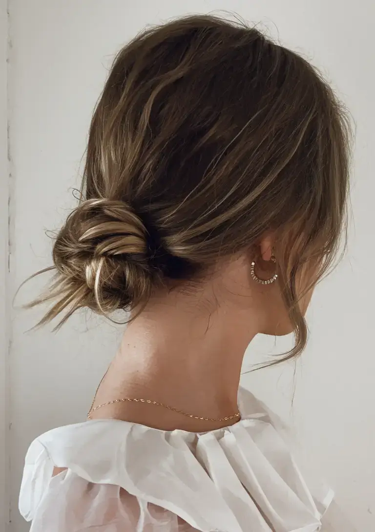 fresh hairstyles for june 2025 Undone Low Knot with Whispy Fringe