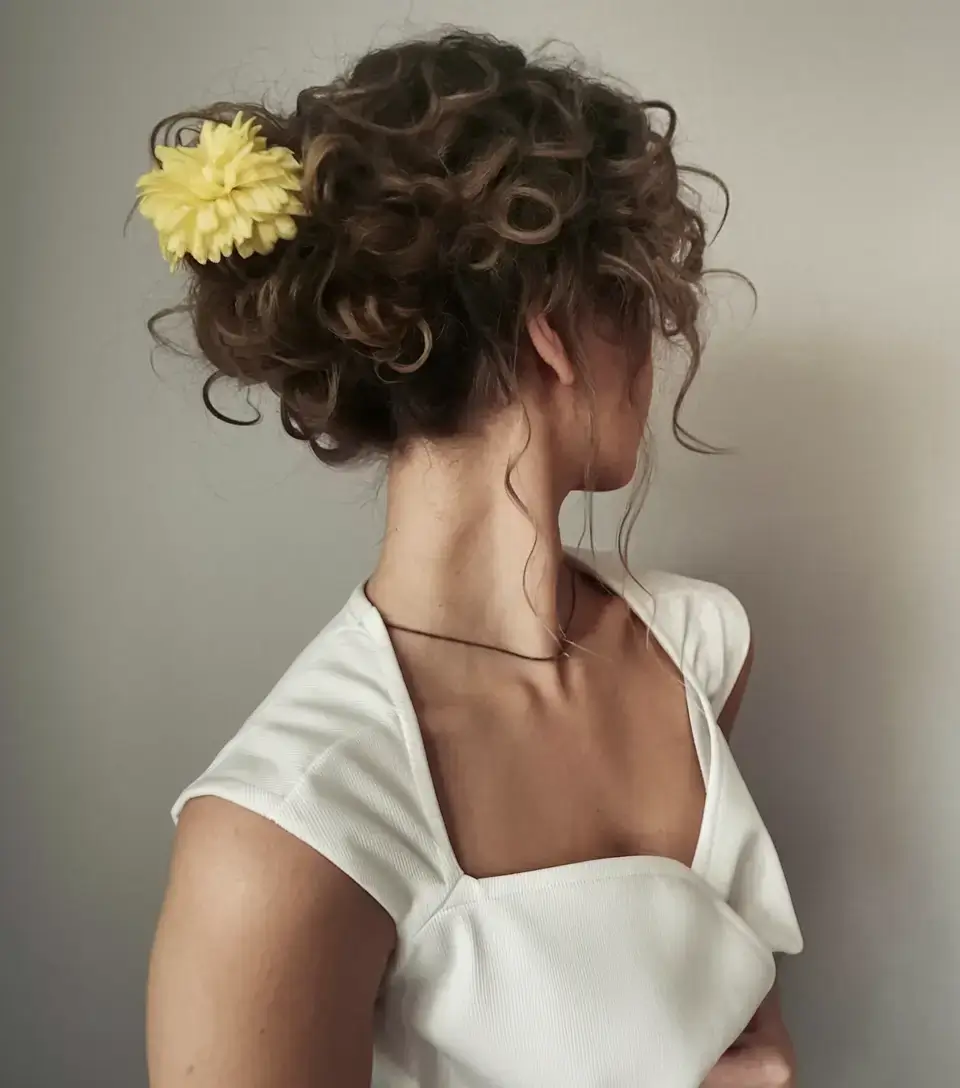summer hairstyles for long hair 2025 Curly Summer Bun with Fresh Floral Accent