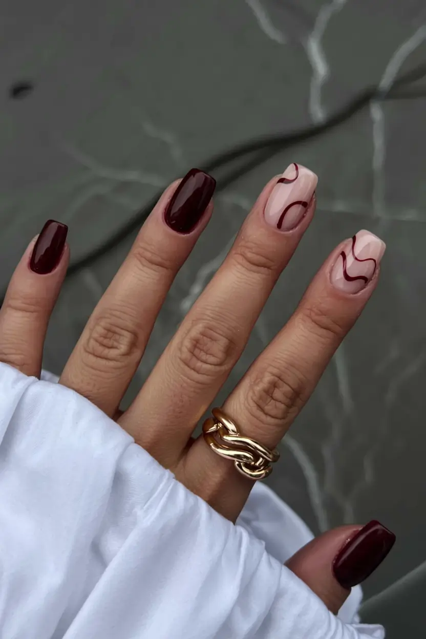 fall 2025 nail trends Wine-Toned Swirls on Nude