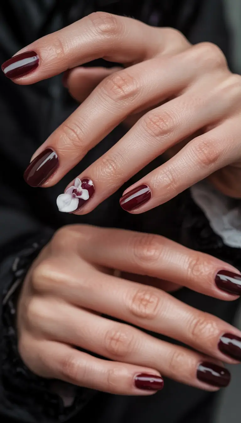 popular fall nail colors 2025 Deep Burgundy with Floral Accent