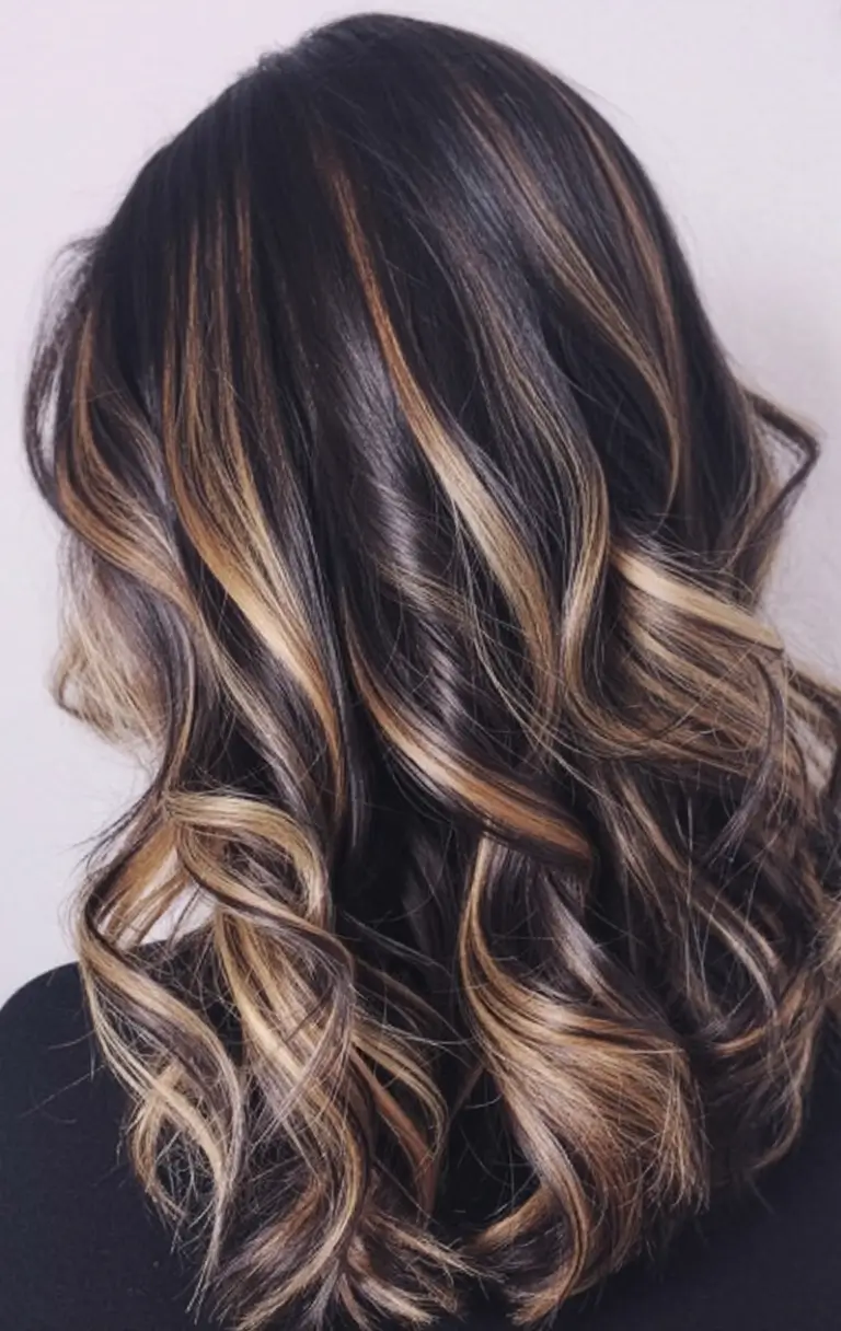 bold spring hair color for brown skin 2026 Warm Caramel Threads on Dark Chocolate Waves