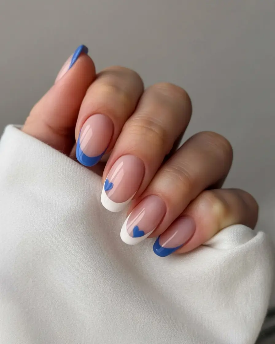 stylish blue spring nails for 2026 White + Blue French Tips with Heart Details