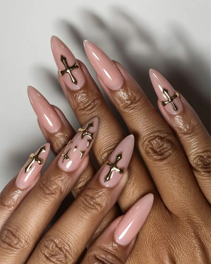 must try spring nails for dark skin 2026 Soft Nude Almond Nails with Gold Cross Accents