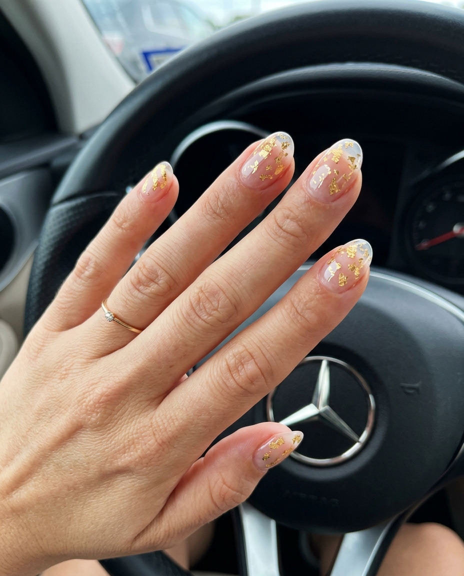 Gilded Glass Accent Nails 2026 Short oval summer nails 2026: Clear glass effect with gold foil accents for a glamorous party look.