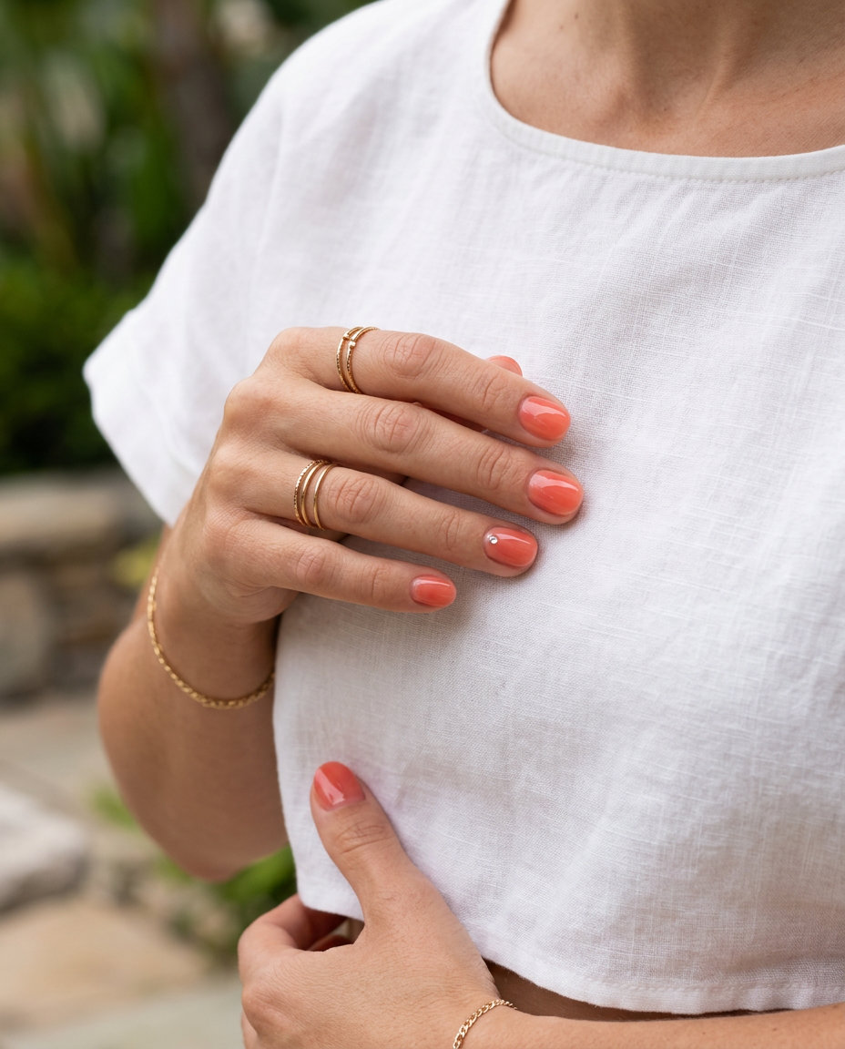 Short round summer nails 2026: Sparkling Coral Dewdrop with rhinestone for parties and date nights.