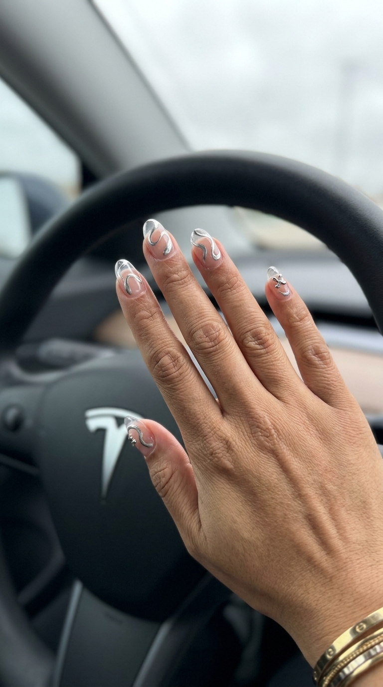 Metallic silver abstract swirls on milky white nails for parties and art gallery visits. Futuristic summer nail manicure ideas 2026.