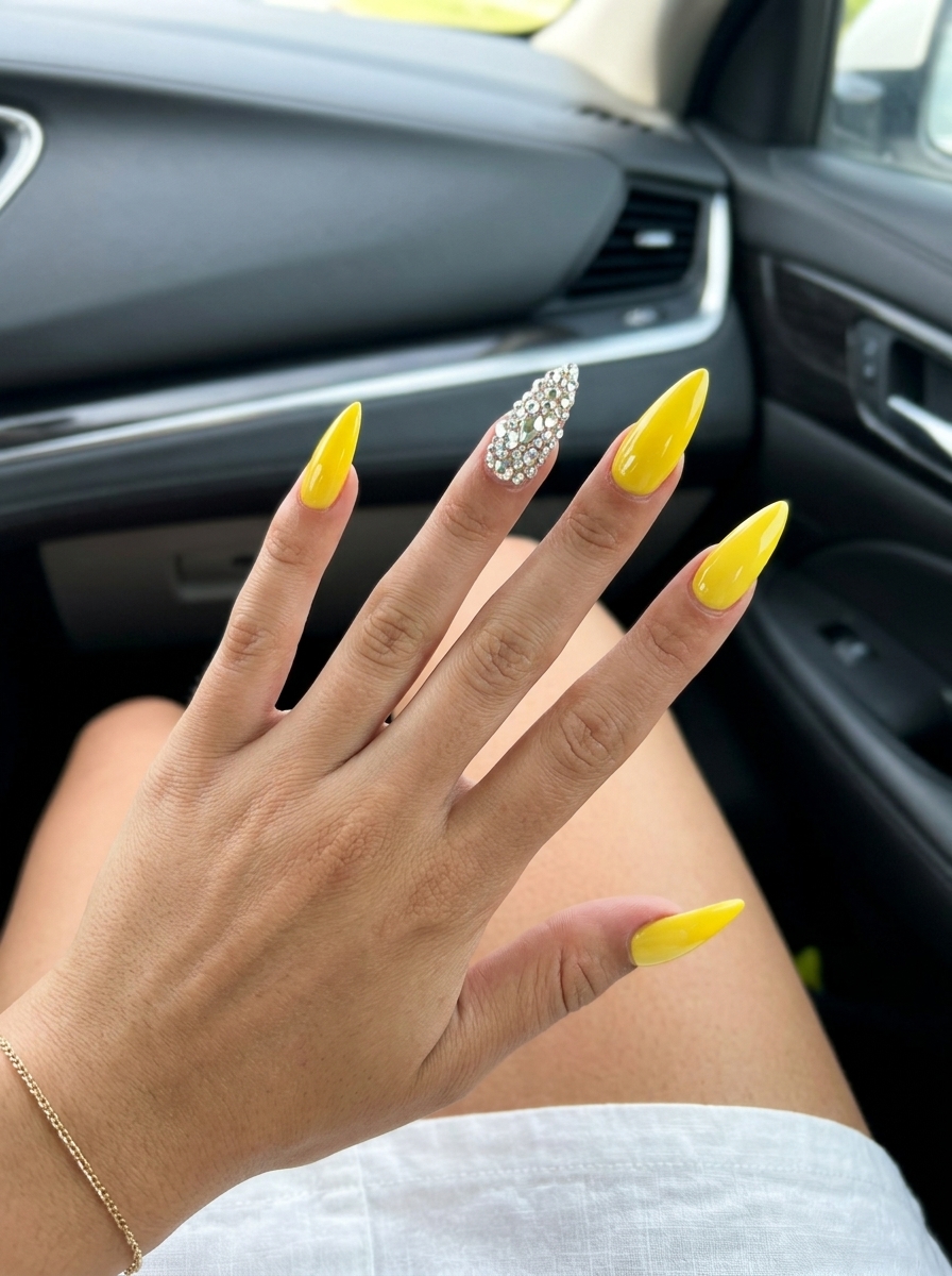 Glamorous canary yellow coffin nails with dazzling rhinestone accent for a party or summer celebration. Yellow summer nails 2026.