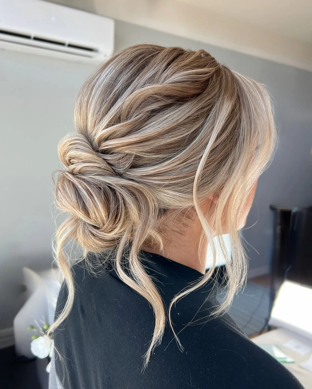 bridesmaid hairstyling Soft Twisted Low Bun With Face Framing Waves