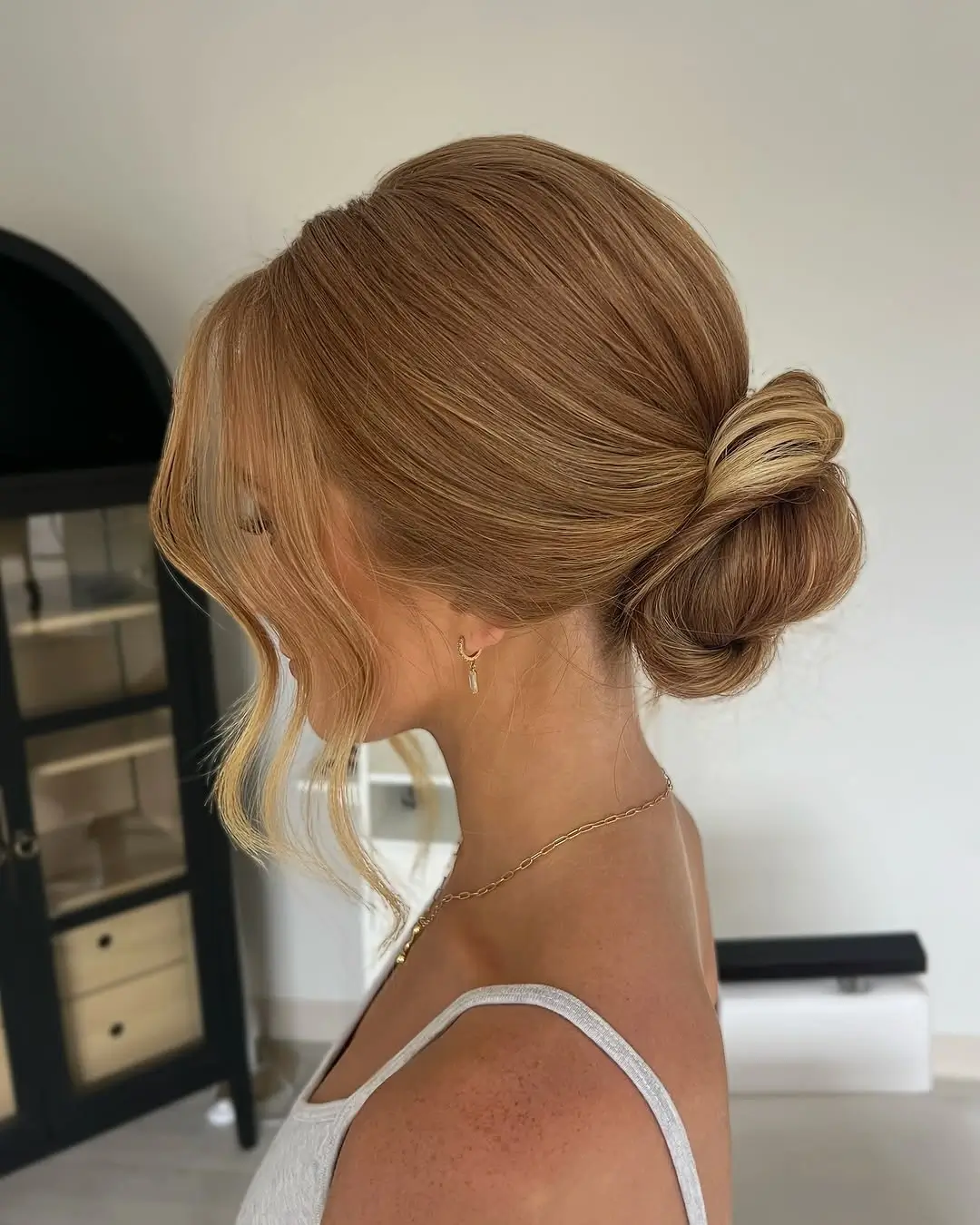 Fall hairstyles for wedding guests 2026 Minimalist Low Knot with Soft Curtain Pieces