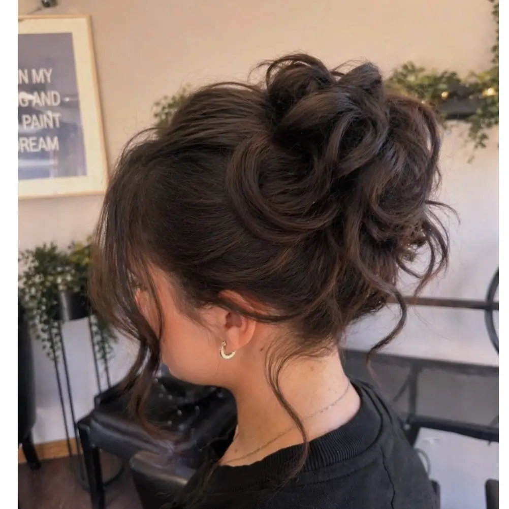 Fall hairstyles for wedding guests 2026 Voluminous Curly Bun with Modern Romance