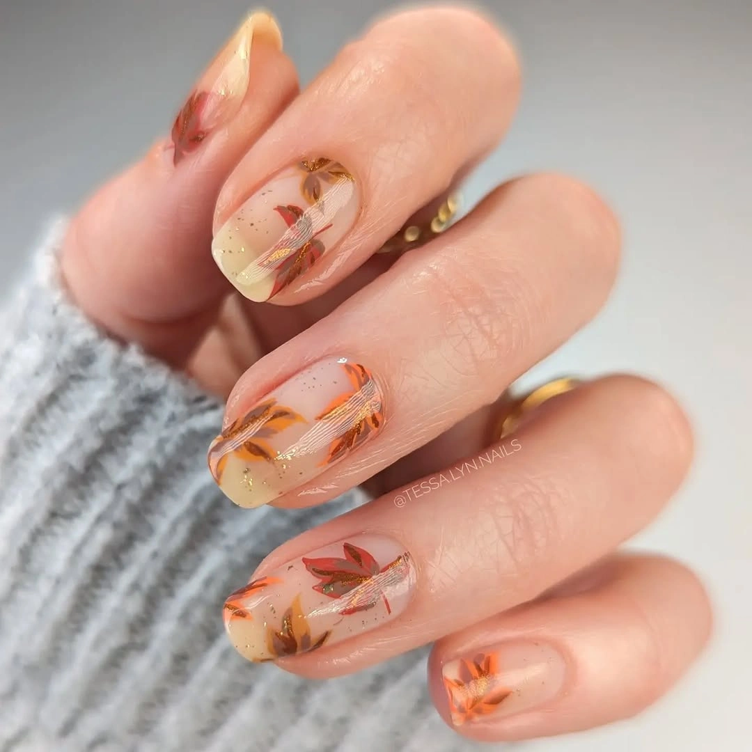 Fall medium nail ideas 2026 Sheer Autumn Leaf Nails With Delicate Gold Accents
