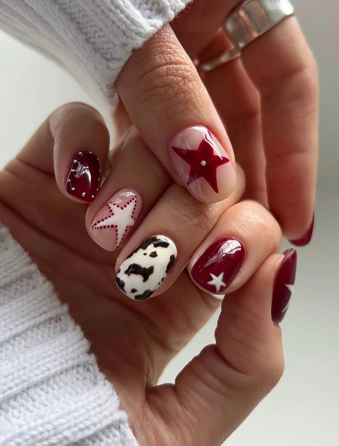 September Nail Art Ideas 2026 Cherry Red Stars with Playful Cow Print Details