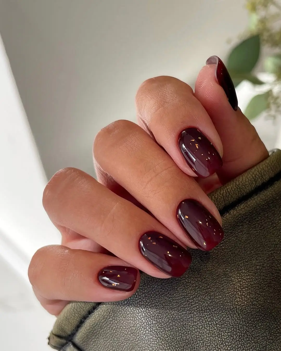 Fall manicure ideas 2026 Glossy Black Cherry Short Nails With Delicate Gold Flakes