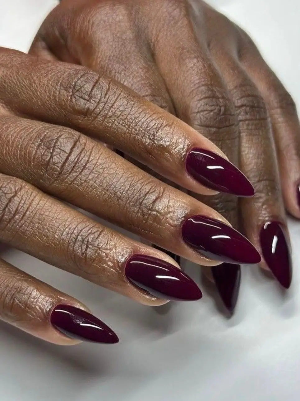 Fall nails colors for dark skin ladies with glossy deep burgundy almond nails