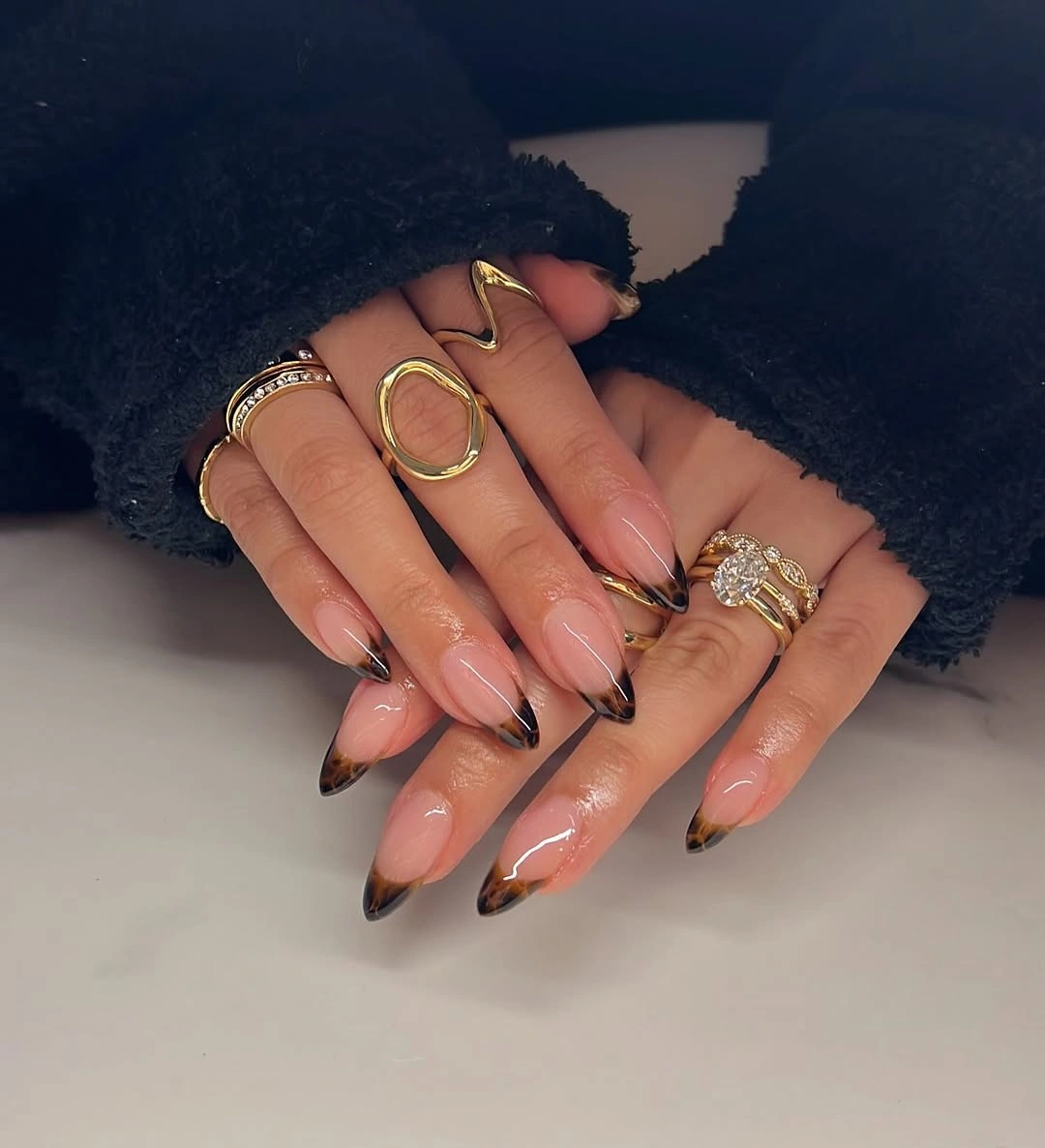 glossy nude almond nails with black tips for fair skin tone