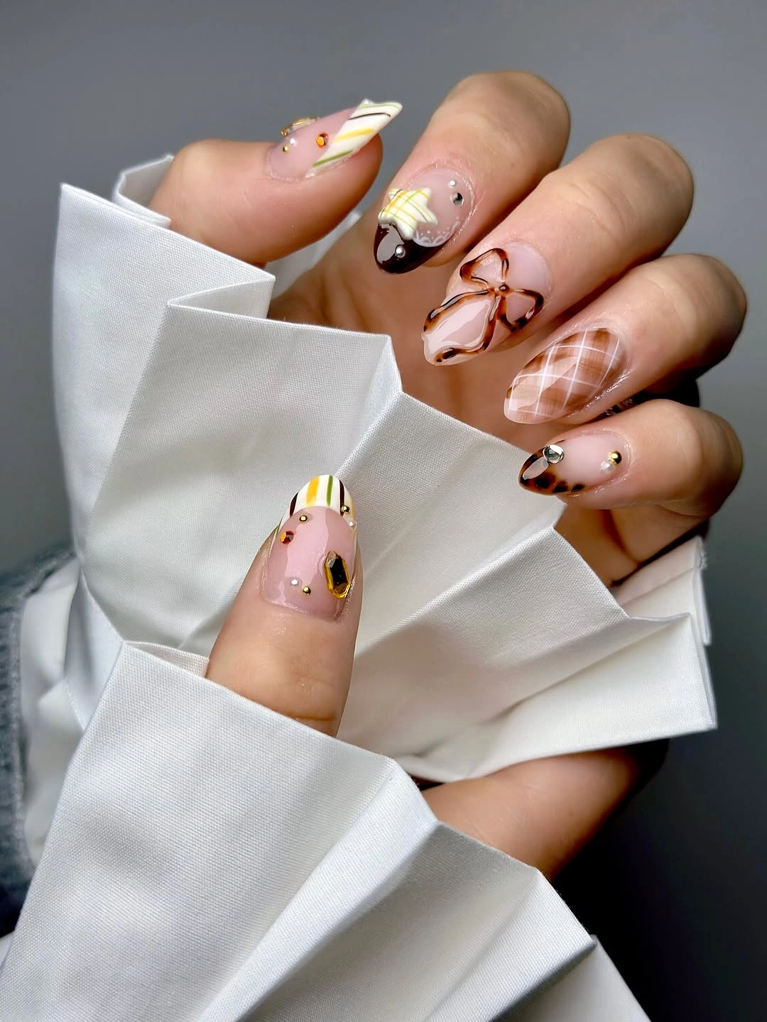 fall trendy nails 2026 playful almond manicure with tortoiseshell plaid and gold details