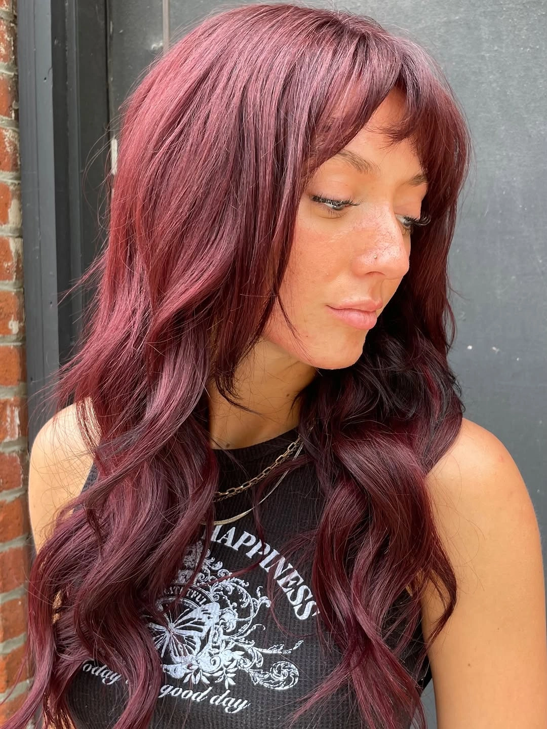 September hair Colour trends 2026 muted plum burgundy with soft curtain bangs