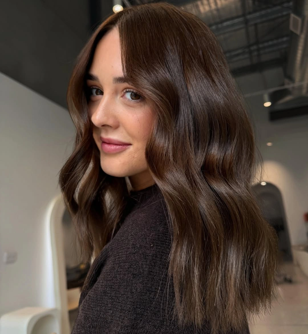 September hair colour trends 2026 deep chocolate brown with glossy face framing waves