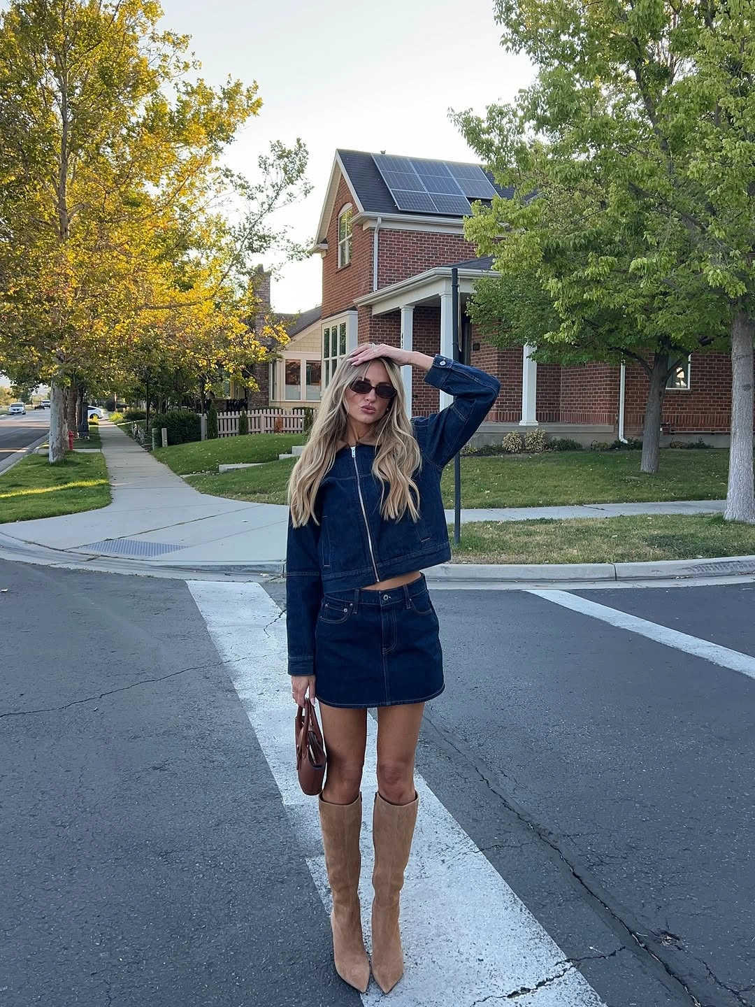 September outfit ideas 2026 dark denim jacket and mini skirt with tall suede boots