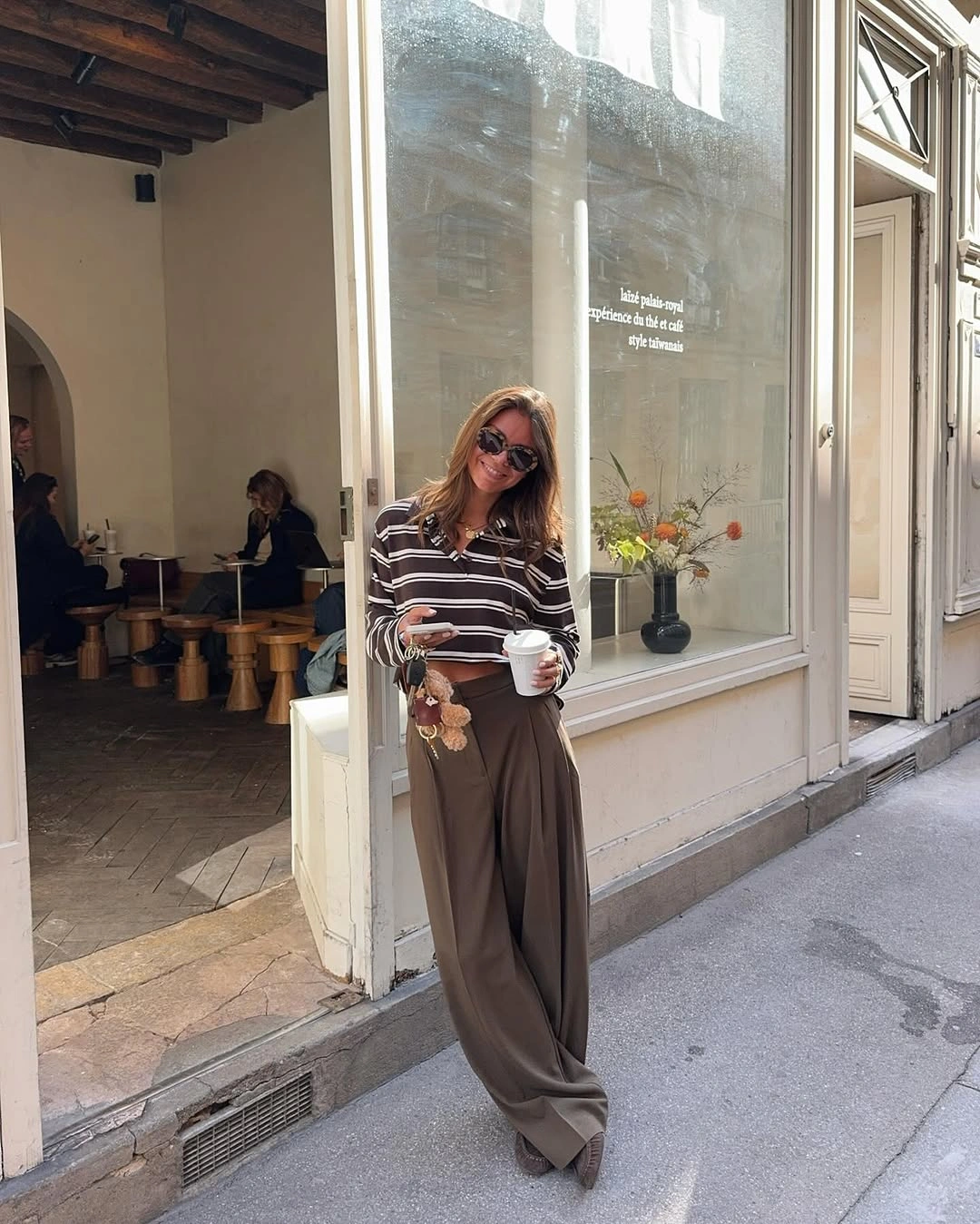 September outfit ideas 2026 Striped polo top and fluid brown trousers for Parisian ease