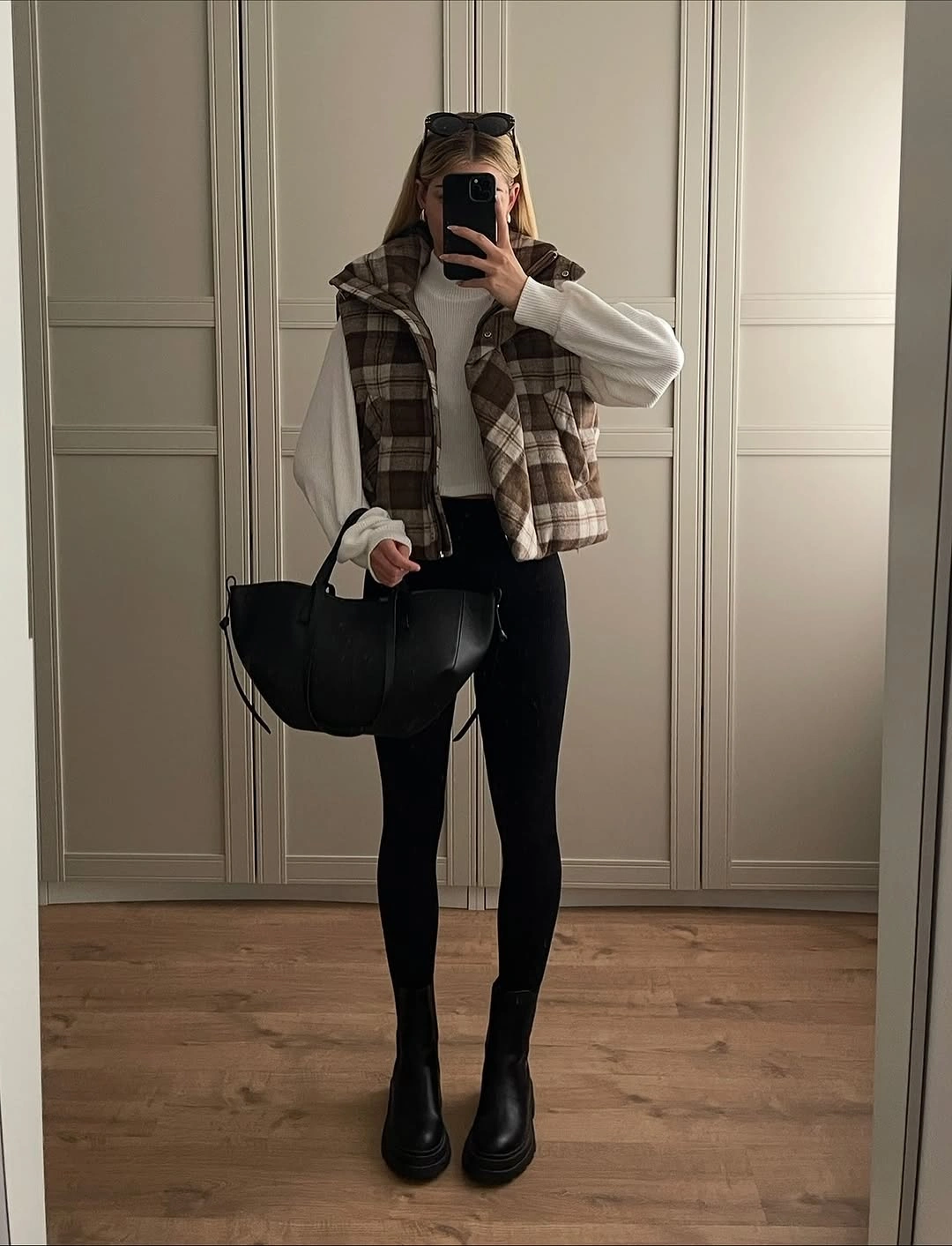 September outfit ideas 2026 Quilted vest and black boots for a crisp early fall layered look