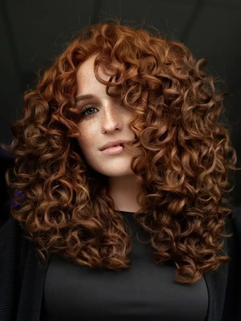 Auburn Curly Layers With Side-Swept Bangs Auburn Curly Layers With Side-Swept Bangs — Winter Hairstyles for Curly Hair