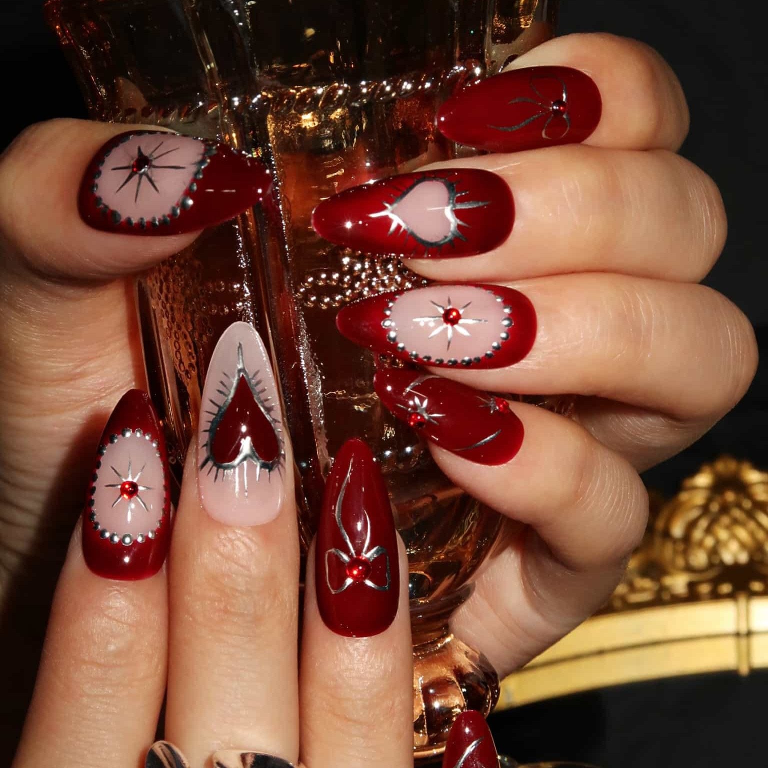 Deep Red Stilettos with Silver Starbursts Deep Red Stilettos with Silver Starbursts — Burgundy Christmas Nails 2026