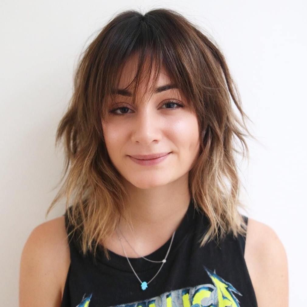 Textured Shag With Wispy Bangs — The Hair Is Brown With Blonde Balayage — Winter Haircuts for Square Faces