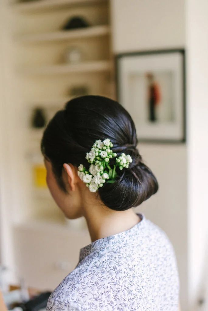 Dark Brown Low Bun With Flower Dark Brown Low Bun With Flower — Winter Updos