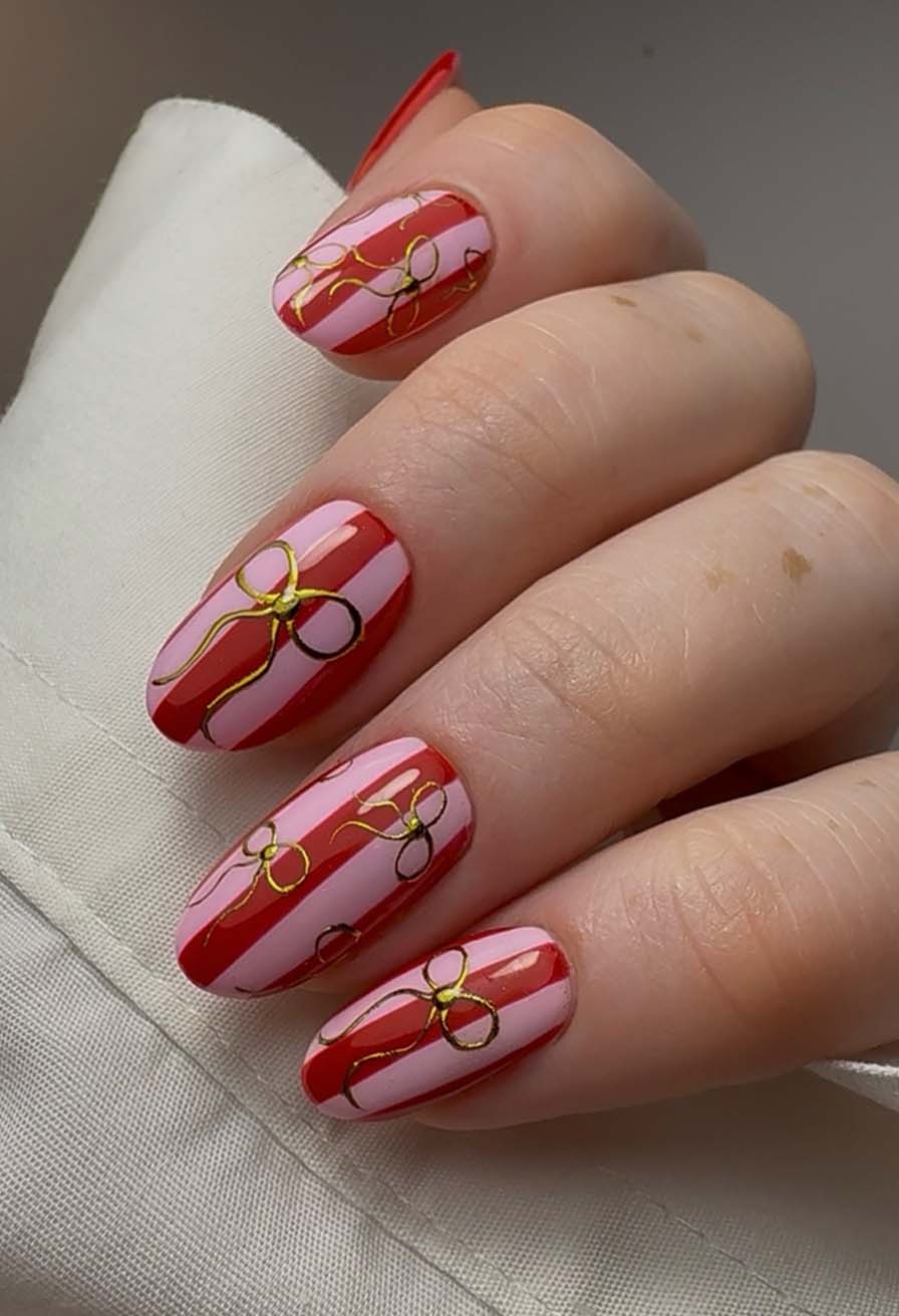 Festive Gold Bow Striped Oval Nails Festive Gold Bow Striped Oval Nails — Christmas Nail Trends 2026