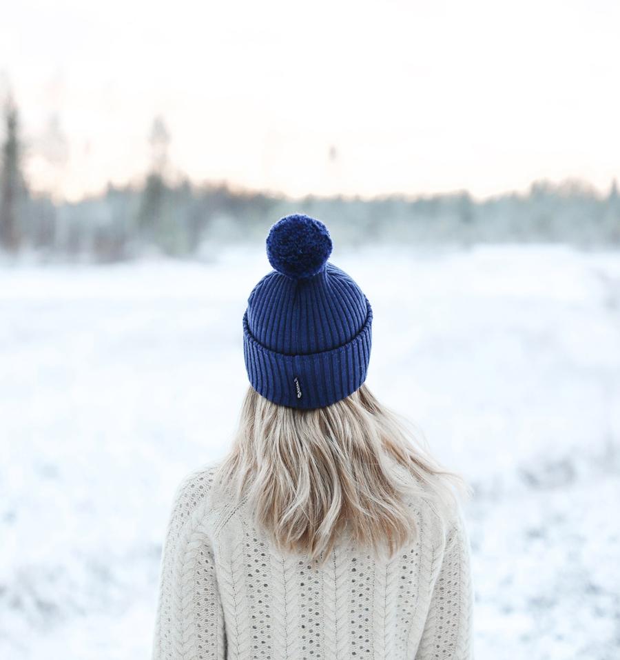 Mid-Back Light Blonde Waves With Blue Pom-Pom Hat — Winter Hat Hairstyles