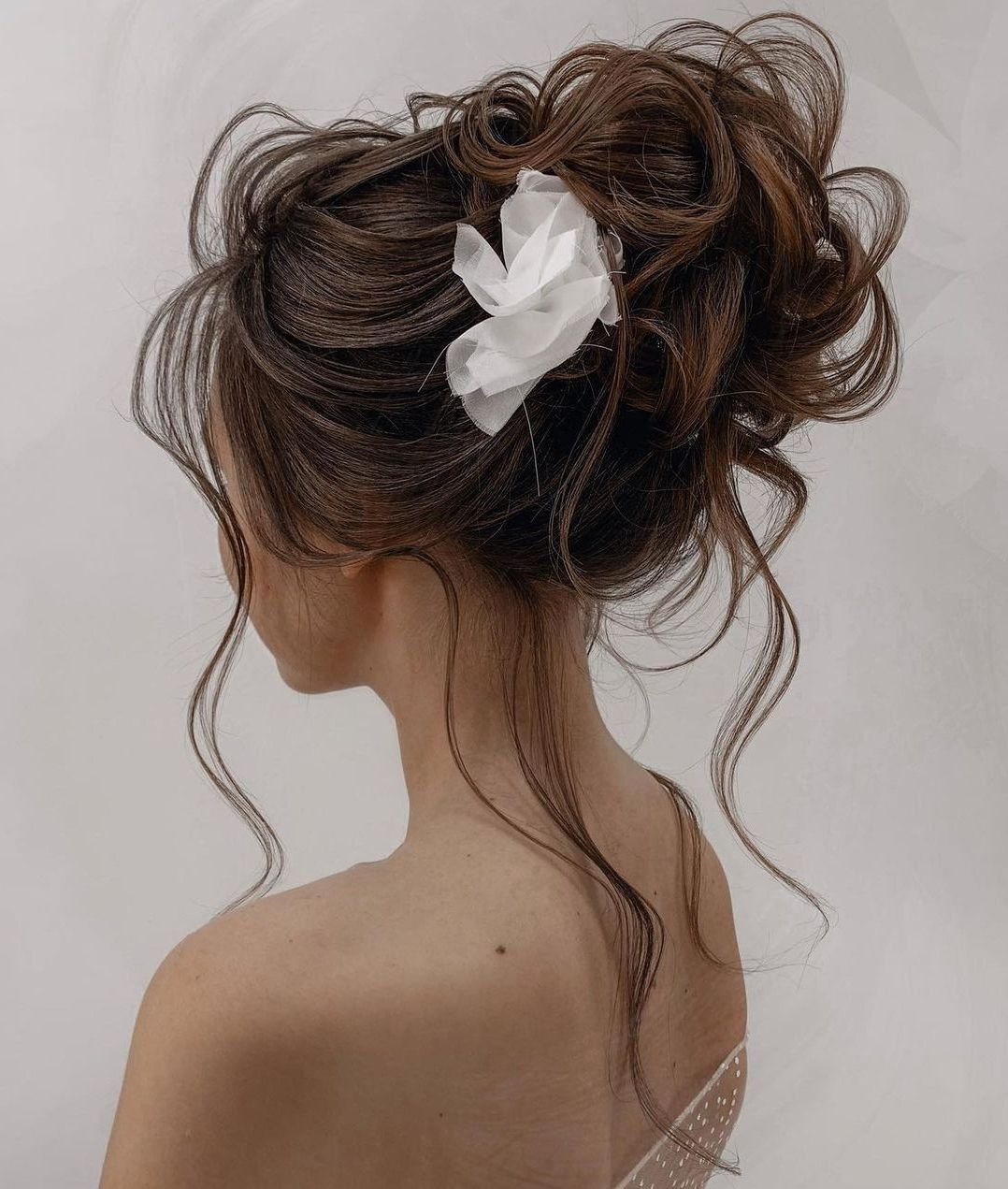 Messy Dark Brown Bun With Face-Framing Tendrils — Winter Bun Hairstyles