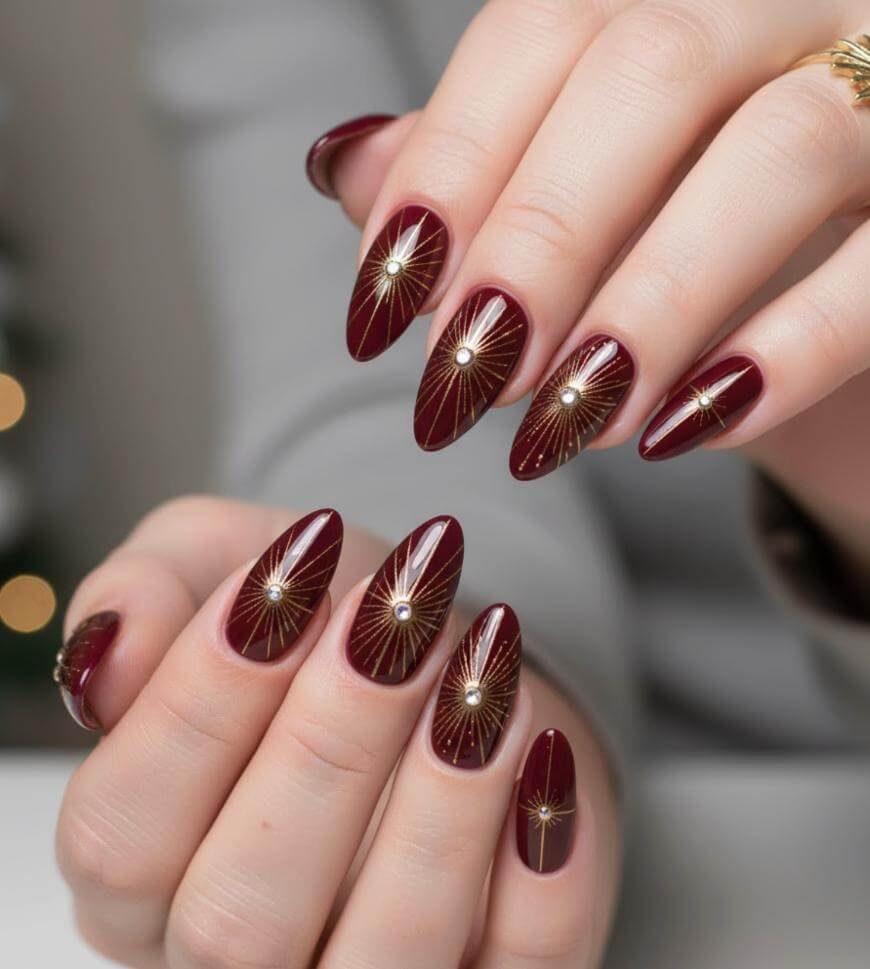 Burgundy Stilettos with Gold Sunburst Art Burgundy Stilettos with Gold Sunburst Art — Burgundy Christmas Nails 2026