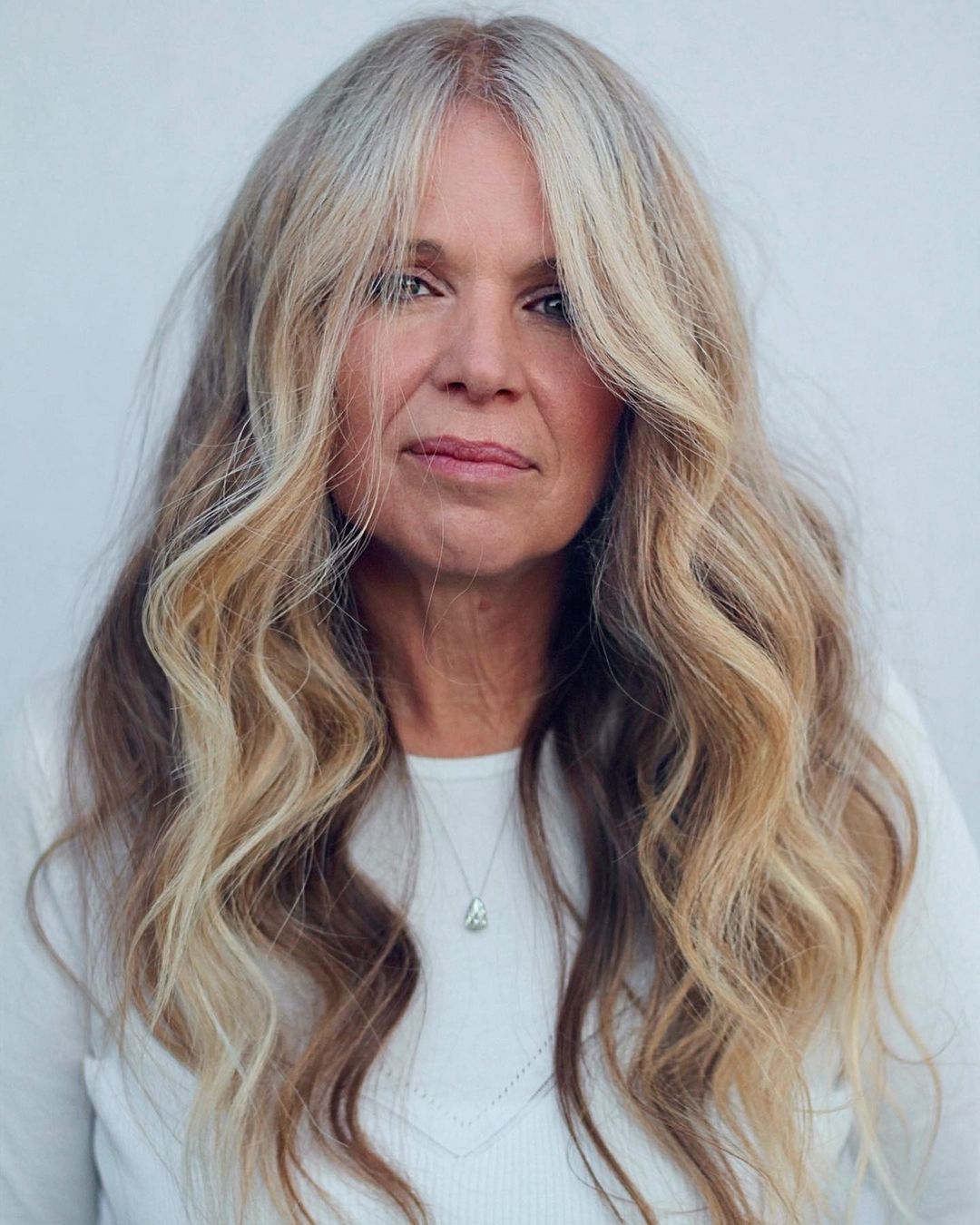 Mid-Back Wavy Hair With Curtain Bangs Mid-Back Wavy Hair With Curtain Bangs — Winter Haircuts for Women Over 50