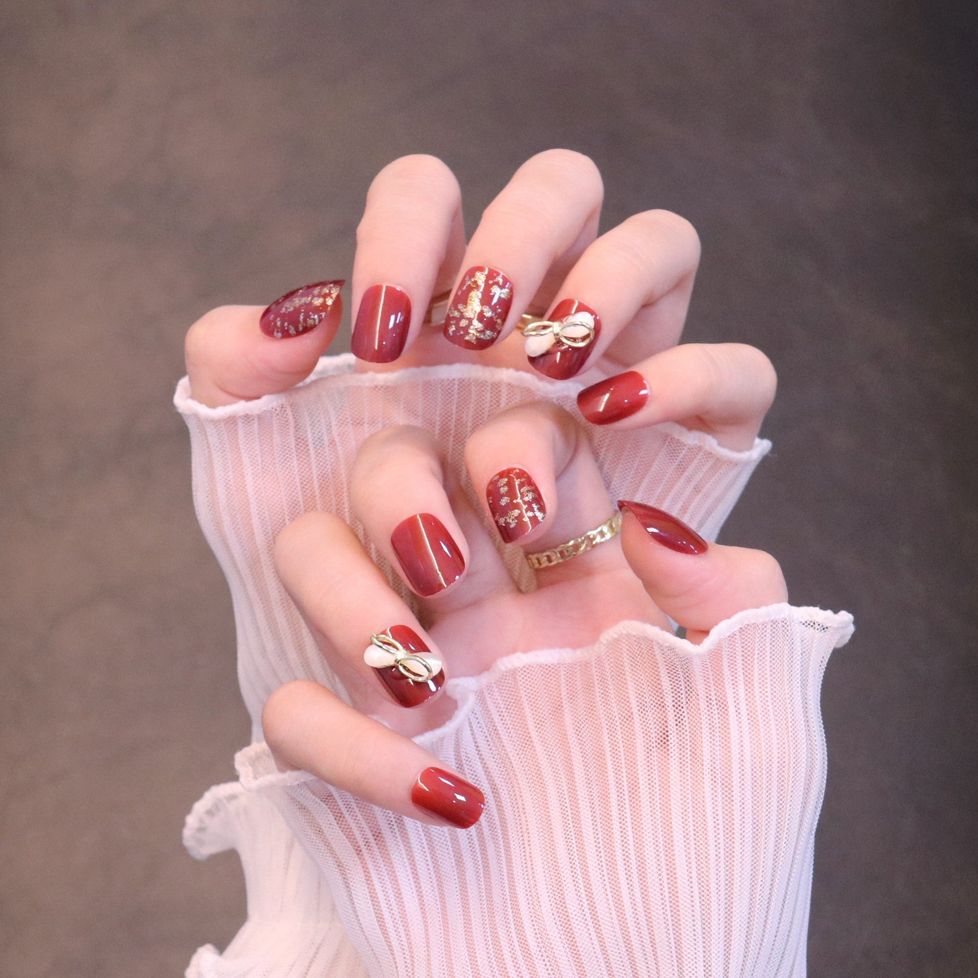 Deep Red Nails With Gold Bow Charms Deep Red Nails With Gold Bow Charms — New Years Press On Nails 2027