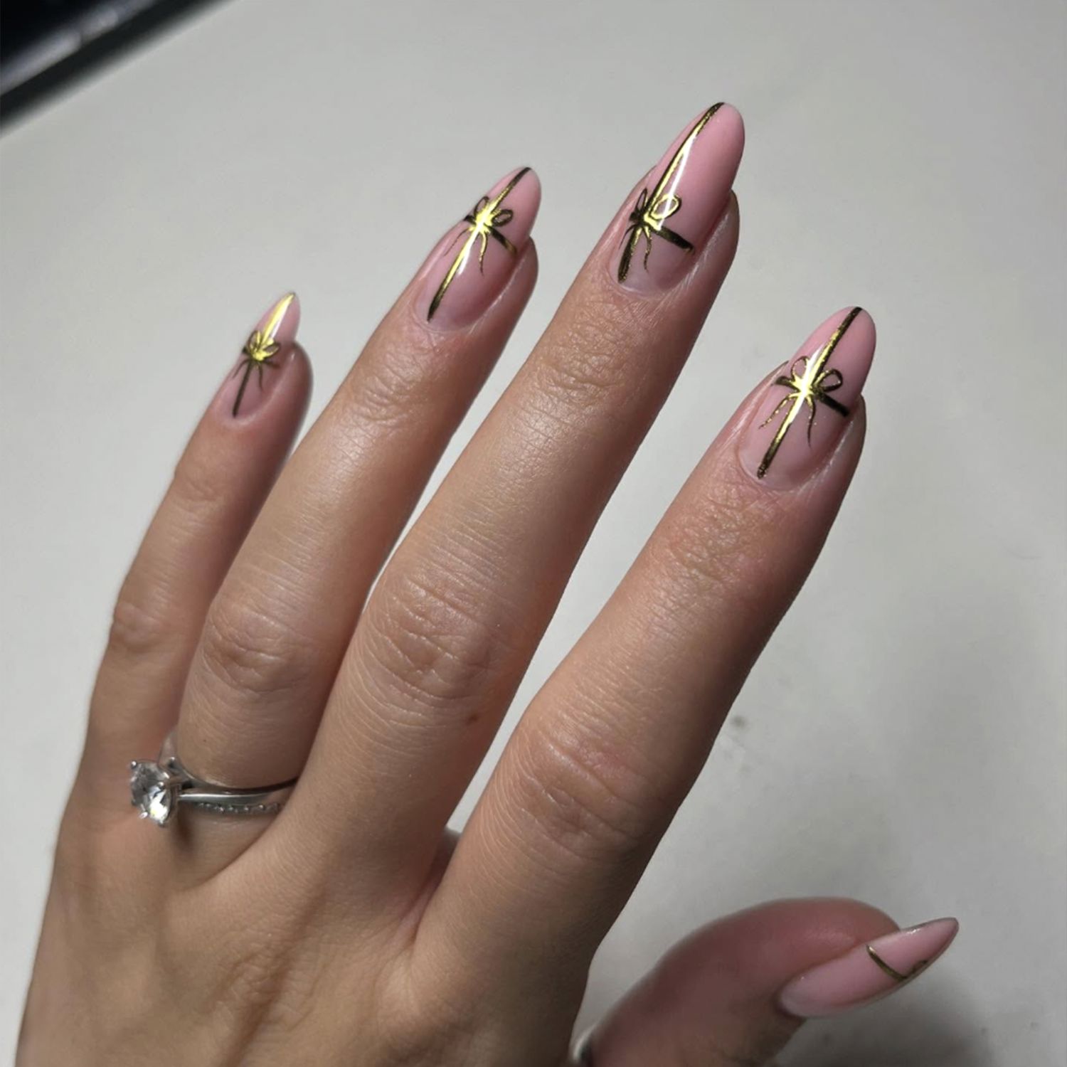 Elegant Gold Foil Bow Stilettos Elegant Gold Foil Bow Stilettos — Christmas Nail Trends 2026